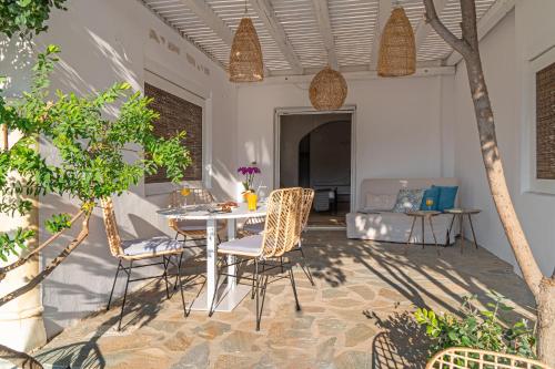 a patio with a table and chairs and a couch at Ornos Blue in Ornos