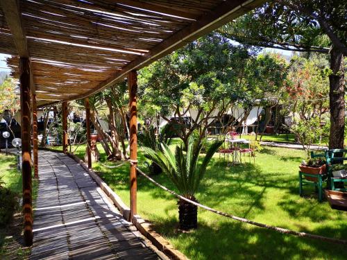 a wooden walkway leading to a garden with a fence at S'Abba Druche rooms in Bosa