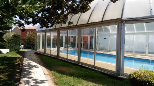 une grande maison en verre avec une piscine dans l'établissement Hotel Villegas, à Valencia de Don Juan