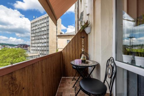 ein kleiner Tisch auf einem Balkon mit Fenster in der Unterkunft Apartment Secret Place in Lwiw