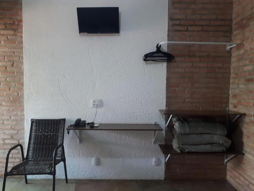 una habitación con una mesa y una silla junto a una pared en Pousada Nuporanga en Nuporanga