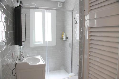 a white bathroom with a shower and a sink at Muro Center in Seville