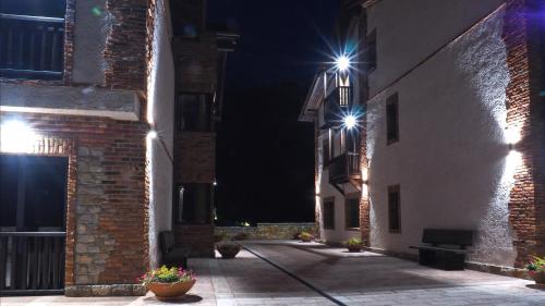 an alley with two buildings at night with lights at Hotel Cerro La Nina in Beceña