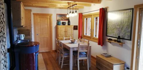 a kitchen with a table and chairs in a room at Tabià Fregona in Fregona