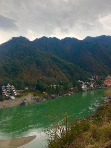a view of a river with mountains in the background at Aloha Apartments by blissful Ganges in Rishīkesh