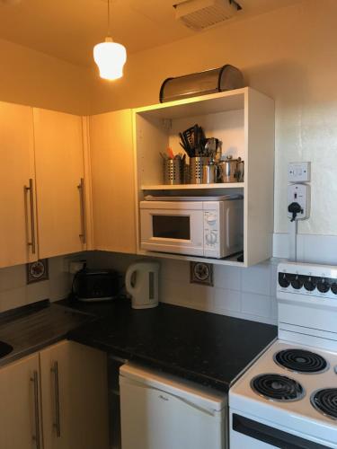 a kitchen with a stove and a microwave at The Kathrene in Fleetwood