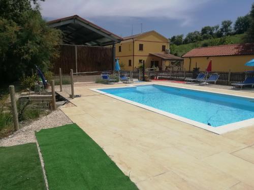 una piscina en un patio junto a una casa en Agriturismo Fattoria del Colle, en Iesi