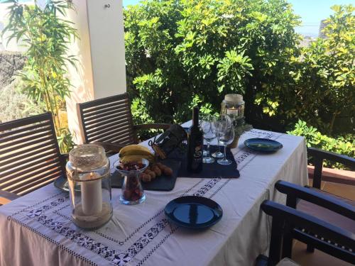 a table with a white table cloth with wine glasses and food at Casa Gloria in Tías