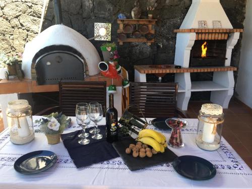 a table with plates and wine glasses and a pizza oven at Casa Gloria in Tías