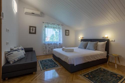 a bedroom with a bed and a couch and a window at Apartment Lungera in Pula
