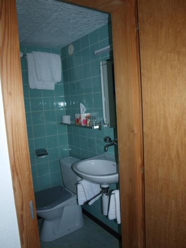 ein Bad mit einem Waschbecken und einem WC in der Unterkunft Gasthof Engelberg in Scharnachtal 