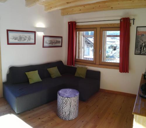 a living room with a black couch and a table at Tabià Fregona in Fregona