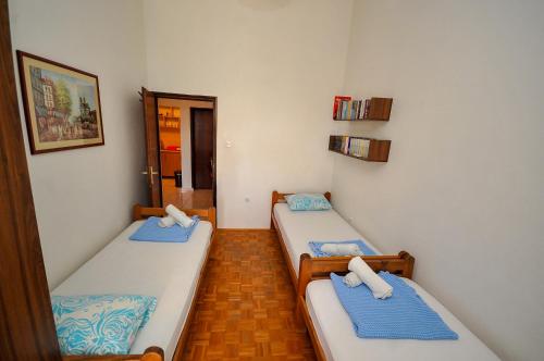 2 camas individuales en una habitación con pasillo en Apartments Kuc, en Bar