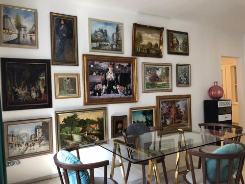a wall of pictures on a wall with a table and chairs at Arthotel ANA Liberty Bremen City in Bremen