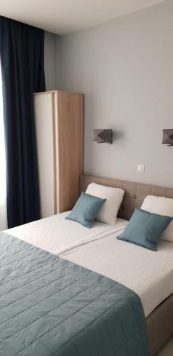 a bedroom with two beds with blue pillows at V-Apartments in Ostend