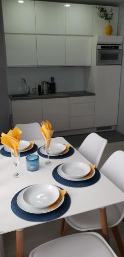 a table with white plates and chairs in a kitchen at V-Apartments in Ostend