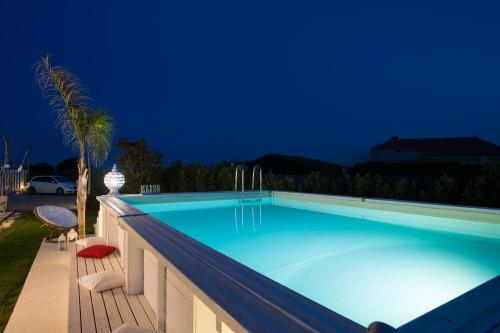 una piscina in un cortile posteriore di notte di Quattro Palme a Marina di Ragusa