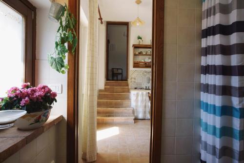 a bathroom with a sink and a hallway with stairs at La Locanda Dell'olmo in Orvieto