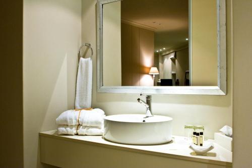 a bathroom with a sink and a mirror at Rouge on Rose Boutique Hotel in Cape Town