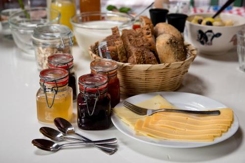 una mesa con una cesta de pan y un plato de queso en Onder de Appelboom, en Garminge