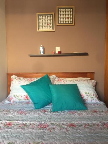 a bed with two green pillows on it at Village Praia de Itacimirim in Itacimirim
