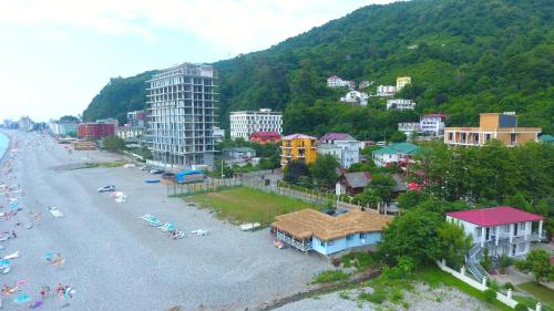 a city with a beach and buildings and a mountain at Medea Kvariati in Kvariati