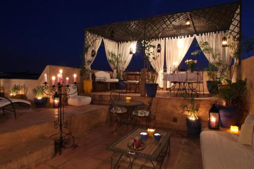 an outdoor patio with candles and tables and chairs at night at RIAD Redous in Marrakech