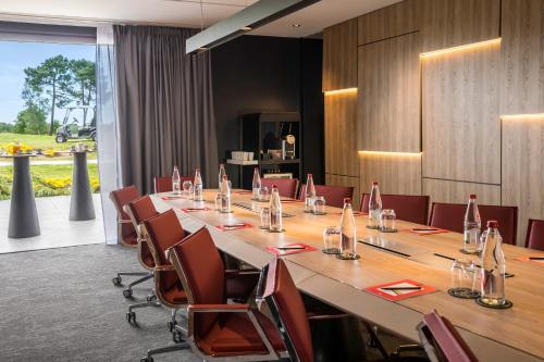 a conference room with a long table and chairs at Cabot Hotel Bordeaux - MGallery Collection in Le Pian-Médoc