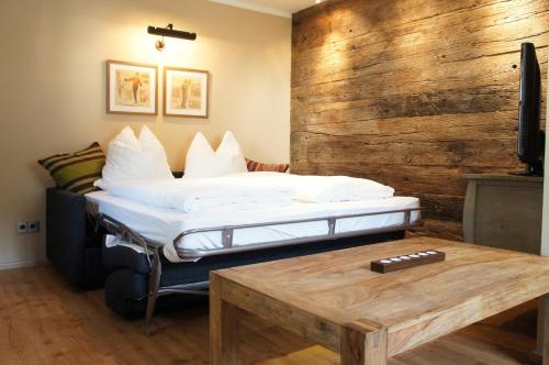 a bed in a room with a wooden wall at Design Apartment Villa Anna Kitzbühel in Kitzbühel