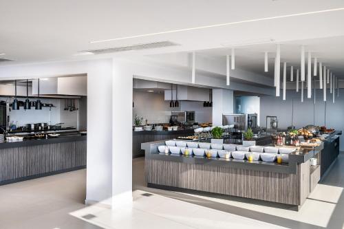 a large kitchen with a counter with a buffet at Porto Platanias Beach Luxury Selection - Adults Only in Plataniás