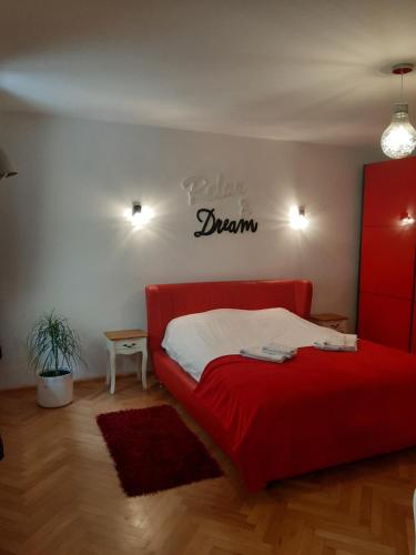 ein Schlafzimmer mit einem roten Bett und einem Schild, das Träume liest in der Unterkunft Luky10 in Braşov
