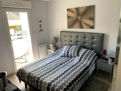 une chambre avec un lit avec une couette noire et blanche dans l'établissement Appartement cosy centre de Wimereux proche plage, à Wimereux