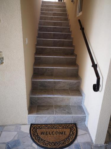 a set of stairs with a welcome mat on the floor at Apartments Gea in Lucija
