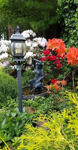 a statue of a bear sitting next to a fountain at Vila Florena Garden in Palanga