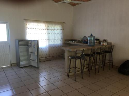 a kitchen with a counter and bar stools at C2 Alberca privada a 5 min de la playa, en planta alta in La Peñita de Jaltemba