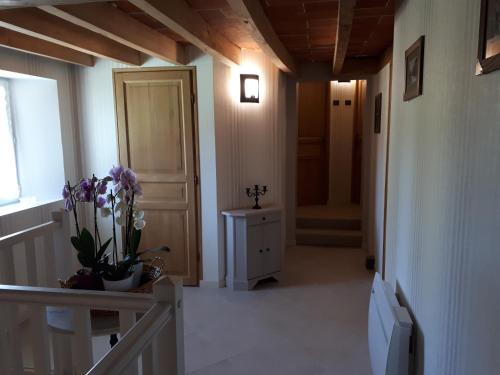 a hallway with a vase of flowers on a table at L'Ayguevives in Faverolles-sur-Cher