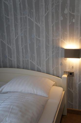 a bedroom with a bed and a wall with trees at Design Apartment Villa Anna Kitzbühel in Kitzbühel