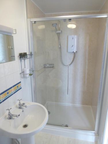 a bathroom with a shower and a sink at Mount Royal - Penzance in Penzance