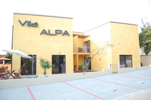 un bâtiment avec un panneau sur son côté dans l'établissement Villa Alpa, à Umag