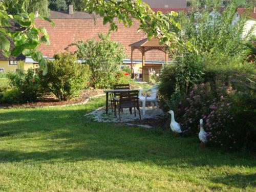 a garden with a table and swans in the grass at Ferienwohnungen Strohmayerhof in Rastenfeld
