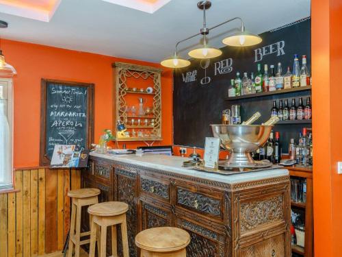 a bar with orange walls and a chalkboard at The Kingsley at Eversley in Eversley