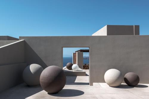 una habitación con un grupo de esculturas de huevo en el suelo en Arota Exclusive Villas, en Akrotiri