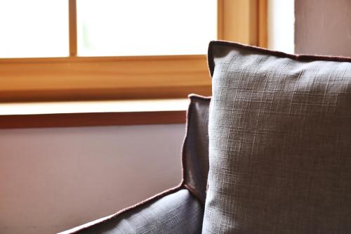 a couch with a pillow in front of a window at Ansitz Jenner in Appiano sulla Strada del Vino