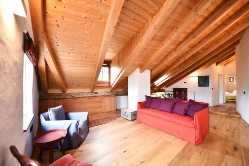 a living room with a red couch and chairs at Ansitz Jenner in Appiano sulla Strada del Vino