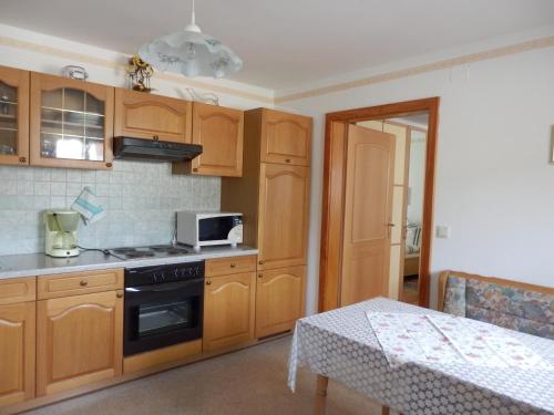 a kitchen with wooden cabinets and a stove top oven at Ferienwohnungen Strohmayerhof in Rastenfeld