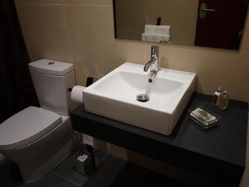 La Portuguesa Apartments في أليكانتي: حمام مع حوض أبيض ومرحاض