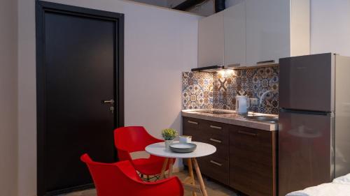 a small kitchen with red chairs and a small table at Wine Inn Borjomi Aparthotel in Borjomi