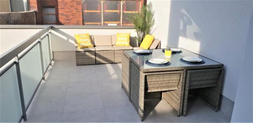 a balcony with a table and a couch at V-Apartments in Ostend