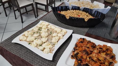 a table with two plates of food and a bowl of food at Hotel Senyor in Rimini