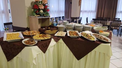 a table with many plates of food on it at Hotel Senyor in Rimini